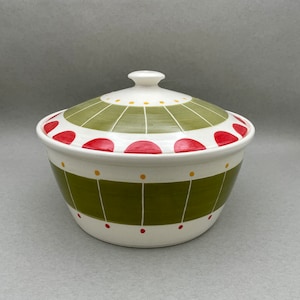 May include: A white ceramic serving dish with a lid. The dish is decorated with green and red geometric patterns.