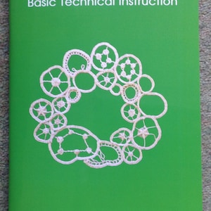 May include: A green book with the title "Needlelace Basic Technical Instruction" and a white lace design on the cover. The book also has the text "The Lace Guild" at the bottom of the cover.