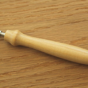 May include: A wooden tool with a metal tip, used for marking or punching holes in materials.