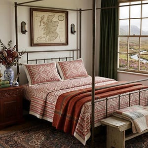 May include: A four-poster metal bed frame featuring bedding with a red and white geometric pattern. A rust-colored throw blanket is draped over the foot of the bed. The bed is positioned in a room with a framed map on the wall and a wooden nightstand.