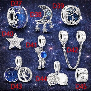 Op de afbeelding: Een collectie zilverkleurige bedels met hemelse thema's, gelabeld van D37 tot D45. De set bevat stervormige kralen, een halve maan, een astronaut, een bedel met ketting en ronde ontwerpen met blauw emaille en heldere steentjes.