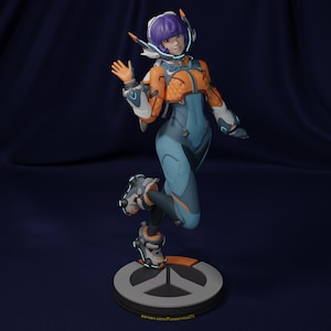 May include: A 3D-printed figurine of a female character in a futuristic outfit. The figure is in a dynamic pose, with a blue and orange color scheme. The base is gray with an orange accent and a logo.