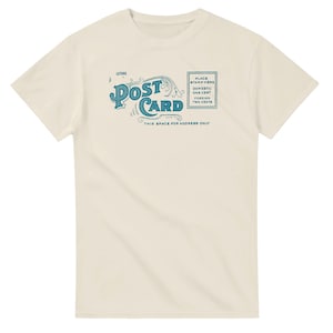 Könnte beinhalten: Cremefarbenes T-Shirt mit einem Vintage-Postkarten-Design in Türkis. Das Design enthält das Wort "POST CARD" in einer stilisierten Schriftart sowie Text, der angibt, wo eine Briefmarke platziert werden soll, und Platz für eine Adresse. Ein lässiges Kleidungsstück.