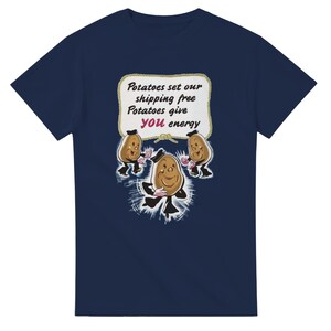 Könnte beinhalten: Ein kurzärmeliges T-Shirt in Marineblau mit einer Grafik von drei Zeichentrick-Kartoffeln mit Armen und Beinen. Darüber befindet sich ein weißes Schild mit Seilrand und dem Text: Potatoes set our shipping free Potatoes give you energy.