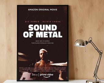 May include: A framed movie poster for "Sound of Metal" with a dark brown background. The poster features the film's title in large white letters, the names of the actors, and the Amazon Prime Video logo. A man is visible in the bottom half of the poster.