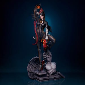 May include: A detailed statue of a character in a black bodysuit with gold stitching, holding a red and gold gun. The figure is standing on a stone sculpture of a winged angel. The background is a gradient of dark blue.