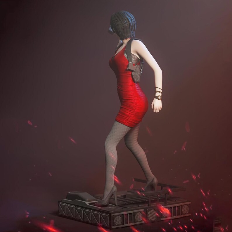 Puede incluir: Una figura de una persona con cabello corto oscuro que viste un vestido corto rojo vibrante sin mangas, una funda de hombro negra y medias oscuras con patr&oacute;n. La figura se encuentra sobre una plataforma mec&aacute;nica rectangular con efectos de luz roja.