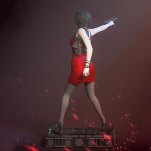 Puede incluir: Una figura coleccionable de pelo corto que viste un vestido rojo sin mangas, medias negras estampadas y tacones altos. La figura sostiene una pistola negra, lleva una funda de hombro y se apoya sobre una base rectangular con rejilla.