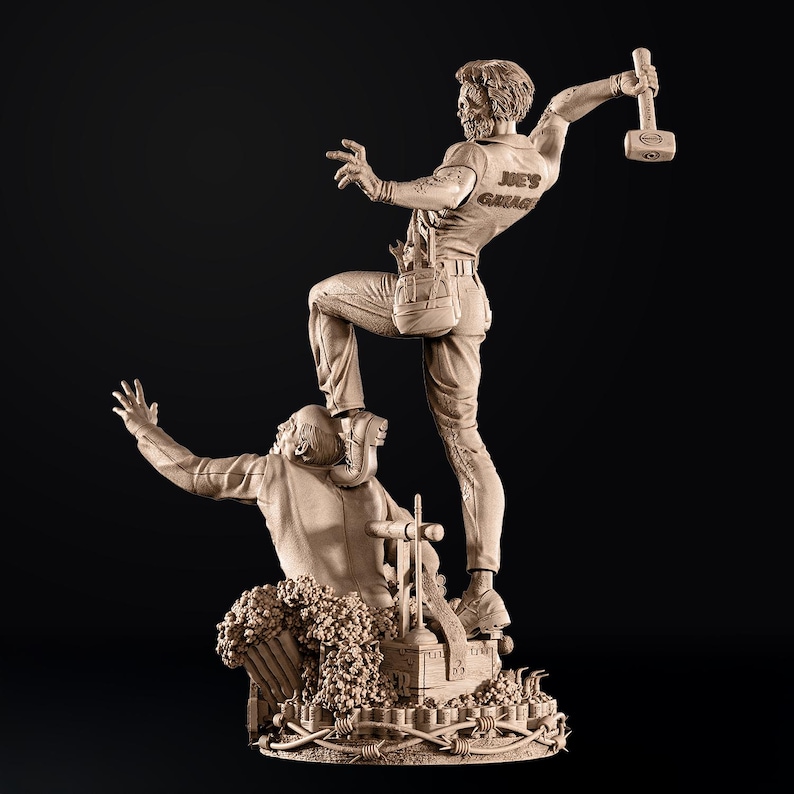 May include: A detailed sculpture depicting two figures in a dynamic pose. One figure stands atop the other, holding a hammer. The sculpture is in a neutral tone, with the text "JOE'S GARAGE" visible on the shirt of the standing figure.