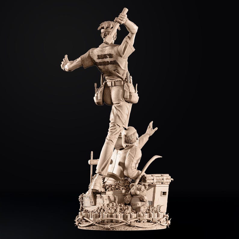 May include: A detailed sculpture of two figures, one standing atop the other. The top figure, wearing a work shirt with "JOE'S GARAGE" on the back, holds a tool aloft. The base features a teddy bear and barbed wire. The sculpture is a light brown color.