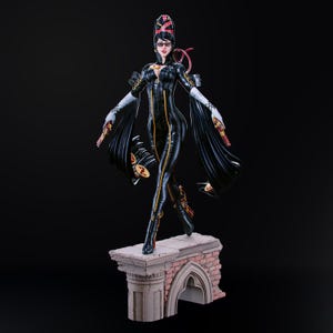 May include: A detailed figurine of a character in a black catsuit with gold accents, holding two guns. The figure has long black hair and is wearing sunglasses and a hat. The figure is standing on a brick and stone platform.