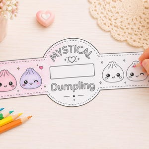 May include: A paper craft strip featuring the text Mystical Dumpling, with illustrations of cute, smiling dumplings. The left side is colored in pink and purple, while the right side remains in black and white outline for coloring.