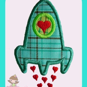 Puede incluir: Un parche de cohete a cuadros turquesa con un corazón rojo en un círculo verde. Llamas rojas en forma de corazón salen de la parte inferior. El parche está delineado con costuras verdes. El texto "Boutique Crazy" está en la esquina inferior izquierda.