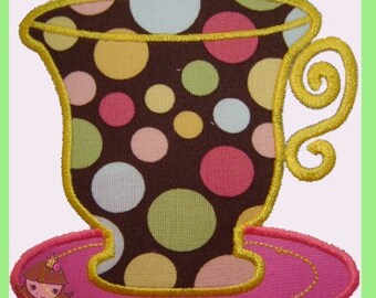 May include: Embroidered teacup and saucer with a brown background and colourful polka dots. The teacup has a yellow trim and handle, and sits on a pink saucer. The design is outlined with yellow stitching.