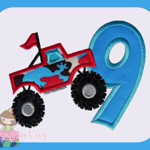 Może przedstawiać: Czerwony monster truck z niebieskimi i kamuflażowymi detalami skacze nad niebieską cyfrą dziewięć. Ciężarówka ma czarną flagę na górze i duże czarne koła.