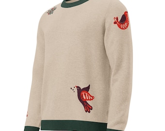 May include: A beige long-sleeve sweater featuring a dark green ribbed crew neckline, cuffs, and hem. The sweater is decorated with embroidered motifs of red and dark purple birds in flight, along with small floral accents scattered across the fabric.
