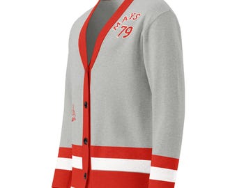 May include: A light gray long-sleeve cardigan with a V-neck and red trim. The front features the red embroidered text "MAYS 79" on the chest. The cuffs and hem have red and white horizontal stripes. The cardigan includes a button-down front closure.