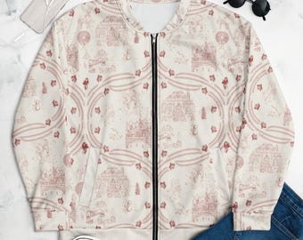 May include: A cream-colored bomber jacket featuring a repeating red line-art pattern of winter scenes, including houses, trees, and small figures. The jacket has a black front zipper, long sleeves, and a ribbed collar, cuffs, and hem.