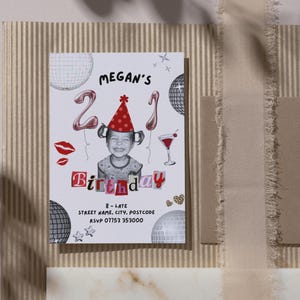 21st Birthday Invitation Template featuring a picture of a toddler wearing a party hat, balloons with a 2 and a 1, disco balls, scrapbook lettering, a cocktail, disco balls, lipstick kisses, sparkles, leopard print hearts and black text with the event details. The invite is on a placemat next to a brown envelope, with the shadow of a tree across the image.