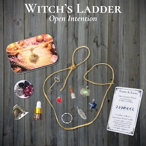 May include: A Witch's Ladder kit featuring a tan cord, metal charms including a key, heart, eye, star, and feather, a small glass bottle, a silver bell, a round container with dried flowers, and a Kismet & Karma card with printed text.