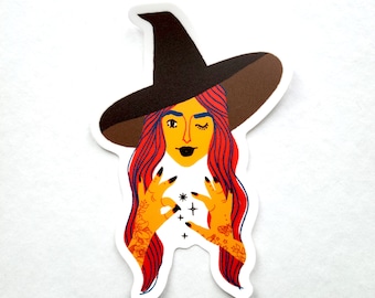 May include: A sticker of a witch with red hair wearing a brown pointed hat. She is holding her hands out in front of her, with her fingers spread out, as if she is casting a spell. There are small stars and a cross in between her hands.