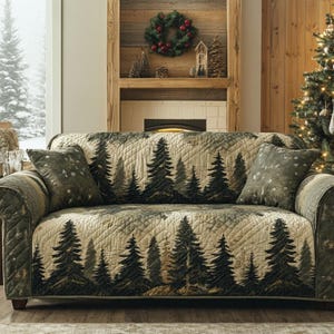 May include: A sofa with a forest-themed quilted cover and matching throw pillows. The cover features a repeating pattern of dark green pine trees against a beige background. The pillows have a similar design with a sprinkling of white accents. The sofa is in a cozy, rustic living room.