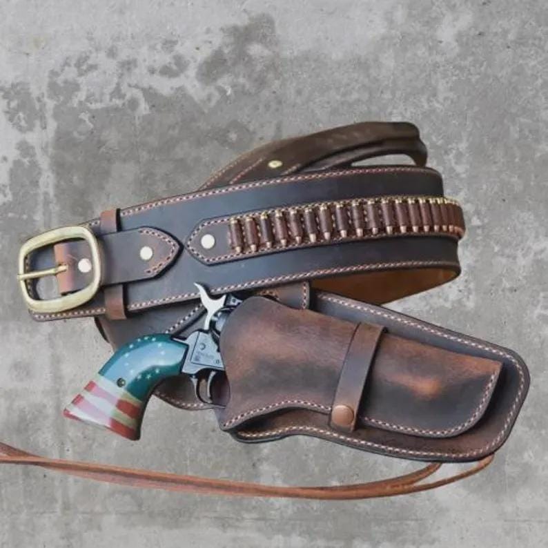 Puede incluir: Un cintur&oacute;n de cuero marr&oacute;n con hebilla dorada y presillas para balas. Una funda a juego contiene un rev&oacute;lver con empu&ntilde;adura azul, blanca y roja. El cintur&oacute;n est&aacute; dise&ntilde;ado para un estilo western.