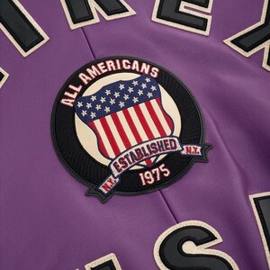 May include: A white ceramic mug with a black handle and the text "But First, Coffee" in a bold, black font. The mug is set against a blurred background, suggesting a cozy setting. The mug appears to be approximately 4 inches tall.