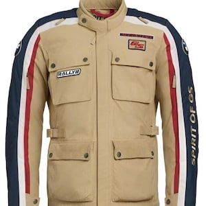 Könnte beinhalten: Beige Motorradjacke mit blauen, weißen und roten Akzenten. Sie verfügt über mehrere Taschen, einen Stehkragen und die Schriftzüge "RALLYE" und "SPIRIT OF GS". Die Jacke hat ein klassisches Design.