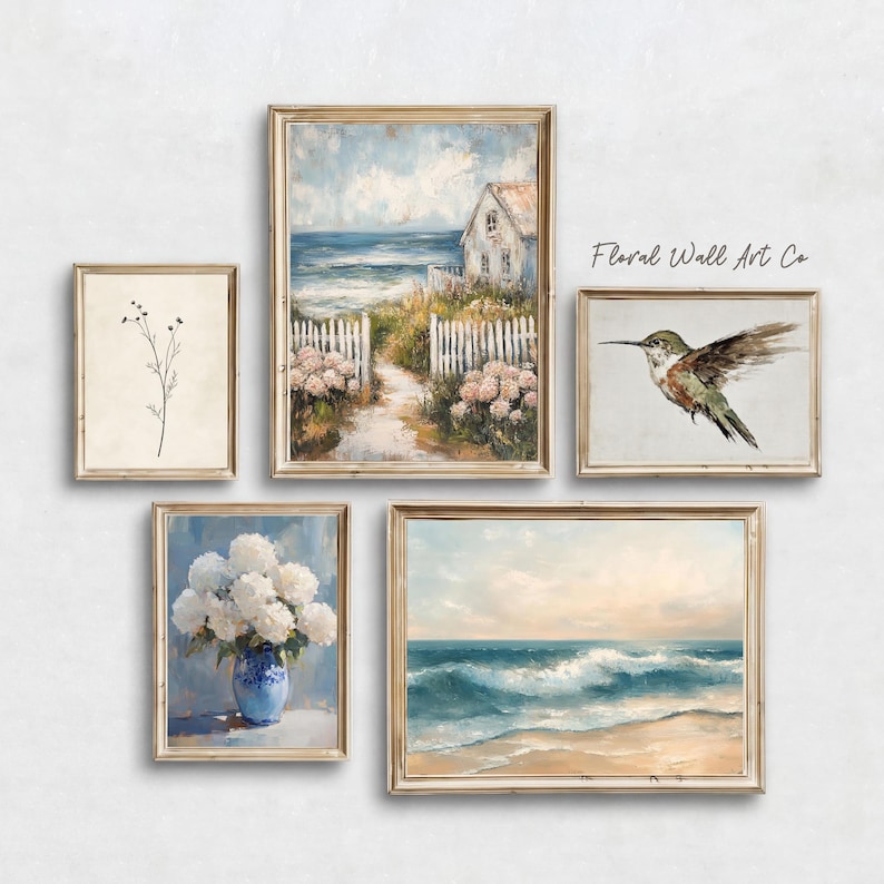 A French country coastal art grouping with five vintage-inspired printable pieces. The set includes a minimal botanical stem, a seaside cottage path leading toward the ocean, a hummingbird study, white hydrangeas in a blue vase, and rolling ocean waves on a sandy shore. The collection keeps the same soft neutral mood as the wider bundle while adding a breezy coastal note through pale sky blues, sea tones, creamy whites, and sun-washed beige.