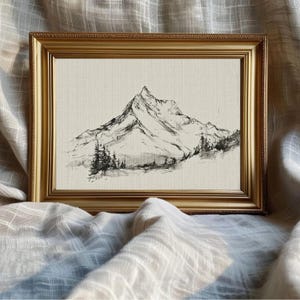 A minimal mountain landscape drawing rendered in fine dark lines on a light neutral ground. The artwork shows a sharp snow-capped peak with lower ridges and a small stand of evergreen trees at the base, giving it the feeling of a vintage sketch or study. The composition is simple, airy, and monochrome, balancing the softer florals and pastoral scenes in the larger French country printable art bundle with a restrained natural subject.