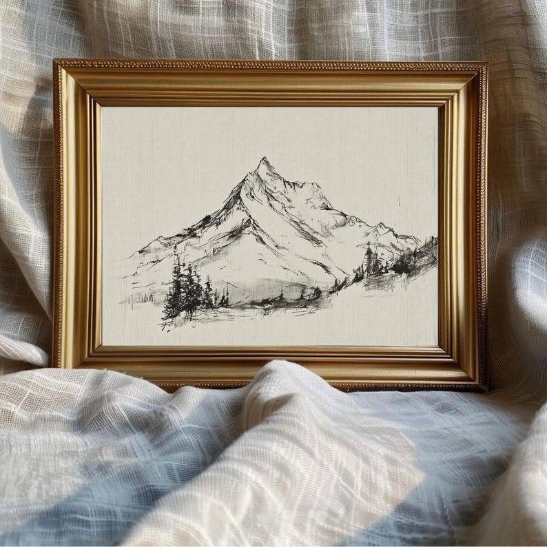 A minimal mountain landscape drawing rendered in fine dark lines on a light neutral ground. The artwork shows a sharp snow-capped peak with lower ridges and a small stand of evergreen trees at the base, giving it the feeling of a vintage sketch or study. The composition is simple, airy, and monochrome, balancing the softer florals and pastoral scenes in the larger French country printable art bundle with a restrained natural subject.