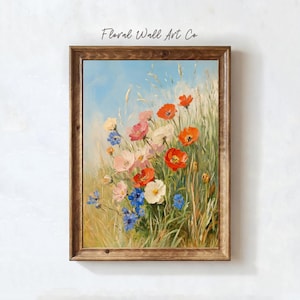 A single floral meadow painting with red poppies, pale pink blossoms, white flowers, and blue cornflower-like accents rising through tall grasses under an open blue sky. The brushwork is loose and painterly, with a bright but still vintage-inspired palette that softens the stronger reds and blues with warm cream and green. The artwork brings a fresh countryside note to the French country printable bundle while staying romantic, classic, and collected.
