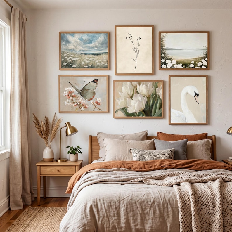 A coordinated French country bedroom art set with five vintage-style printable pieces. The artworks show a cloud-filled sky over a field of white blooms, a minimal stem botanical, a pale coastal landscape framed by white flowers, a butterfly hovering over soft blossoms, white tulips painted in loose brushstrokes, and a swan portrait on a warm neutral background. The palette is airy and calming with beige, cream, muted green, blue, and soft peach tones.