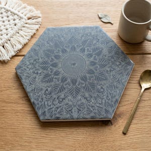 May include: A set of three ceramic mugs with a speckled, matte finish. The mugs are in shades of cream, light gray, and dark gray. Each mug has a simple, minimalist design and a rounded handle.