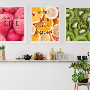 Può includere: Tre stampe artistiche incorniciate con bordi bianchi. Le stampe presentano immagini ravvicinate di frutta: litchi con il testo "Sweet Life", arance e limoni con il testo "When Life Gives You Lemons" e kiwi con il testo "Stay Juicy".