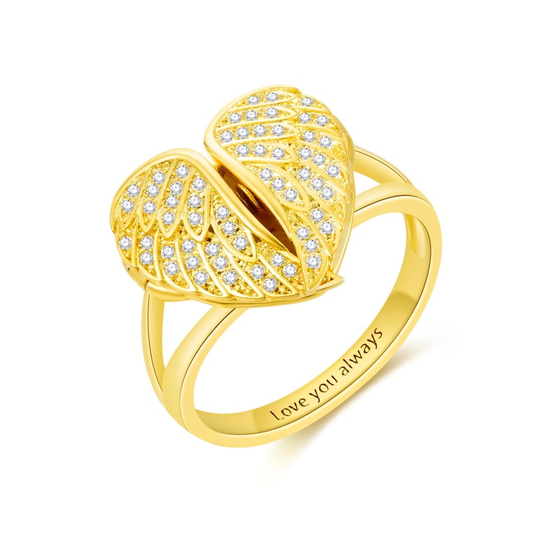 May include: A gold-colored ring featuring an angel wing design, encrusted with small, clear gemstones. The ring has a split shank and the words "Love you always" are engraved on the band.