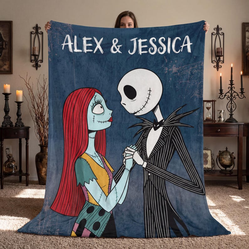 Puede incluir: Una manta de forro polar azul con Jack Skellington y Sally de Pesadilla antes de Navidad, tomados de la mano. La manta tiene los nombres "ALEX & JESSICA" en texto blanco en la parte superior. Los personajes est&aacute;n a color sobre un fondo azul.