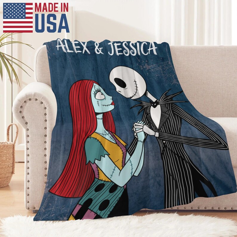Puede incluir: Una manta azul con una ilustraci&oacute;n de dibujos animados de Sally y Jack Skellington de The Nightmare Before Christmas. La manta tiene el texto "ALEX & JESSICA" y "MADE IN USA" con la bandera americana.