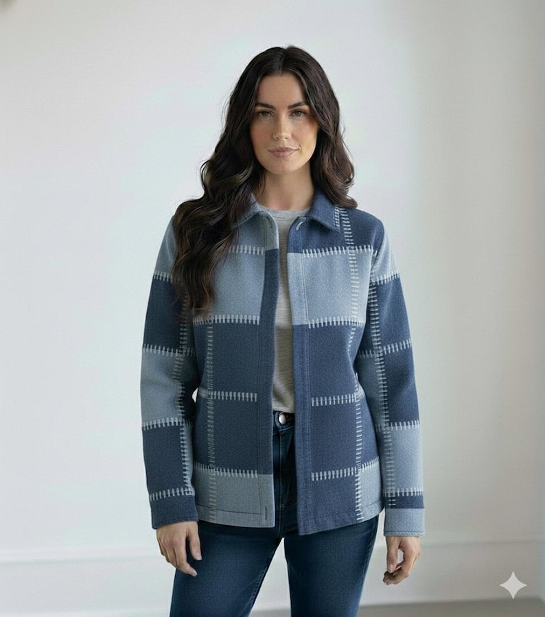 May include: A blue and grey patchwork jacket with a collared neckline and button closure. The jacket has a geometric pattern with visible stitching. The model is wearing a grey t-shirt and blue jeans.