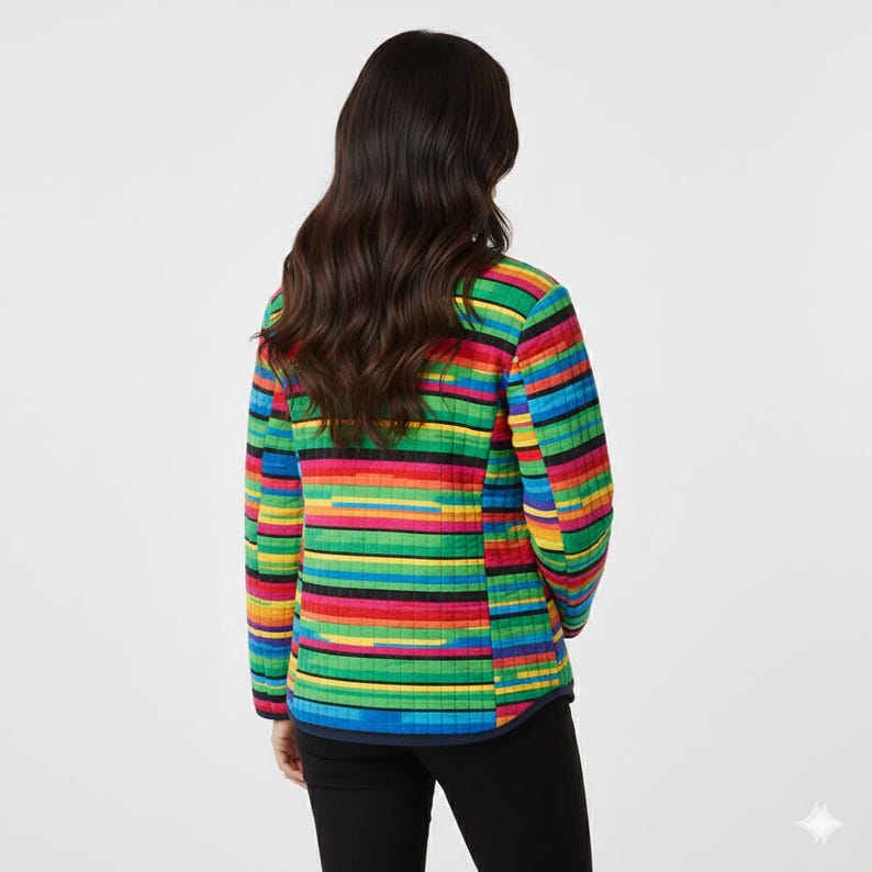 Pu&ograve; includere: Giacca trapuntata a righe orizzontali multicolori, con colori vivaci come rosso, giallo, verde e blu. La giacca ha maniche lunghe e un bordo blu scuro. La persona indossa pantaloni neri.