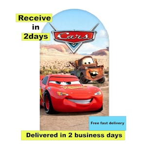 May include: A vibrant image featuring characters from the animated movie "Cars." Lightning McQueen, a red race car, is prominently displayed alongside Mater, a rusty tow truck. The background depicts a desert landscape. Text includes "Receive in 2 days" and "Delivered in 2 business days."