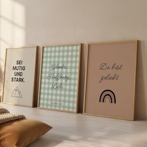 May include: Three framed art prints with inspirational quotes. The first print has the text "SEI MUTIG UND STARK." The second print has the text "Glaube, Hoffnung, Liebe." The third print has the text "Du bist geliebt" and a rainbow.