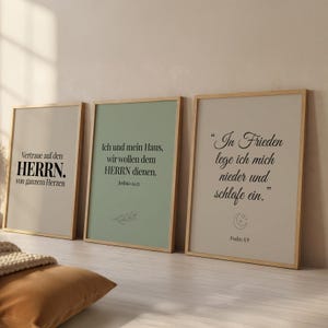 May include: Three framed art prints with inspirational quotes in German. The frames are light wood, and the prints have a neutral color palette with black text. The quotes are from the Bible, including verses from Joshua and Psalms.