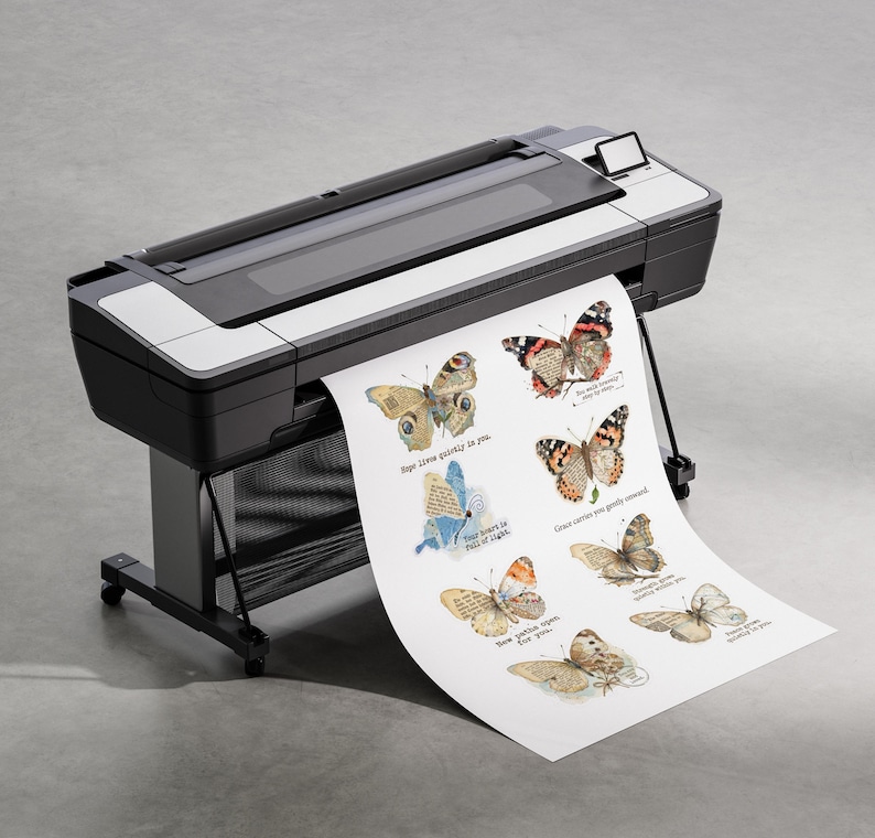 May include: A large format printer in black and white with a paper roll extending outward. The paper features a series of detailed butterfly illustrations in various colors, each accompanied by small printed text phrases in black ink.