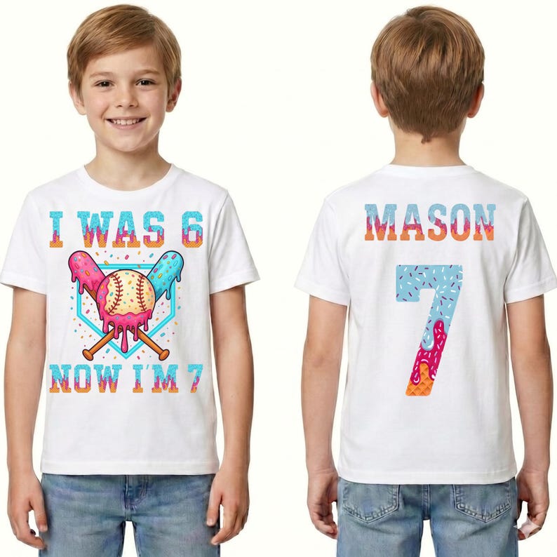 May include: White t-shirt with a colorful baseball-themed design. The front features the text "I WAS 6 NOW I'M 7" with a baseball and crossed bats. The back displays the name "MASON" and the number "7".