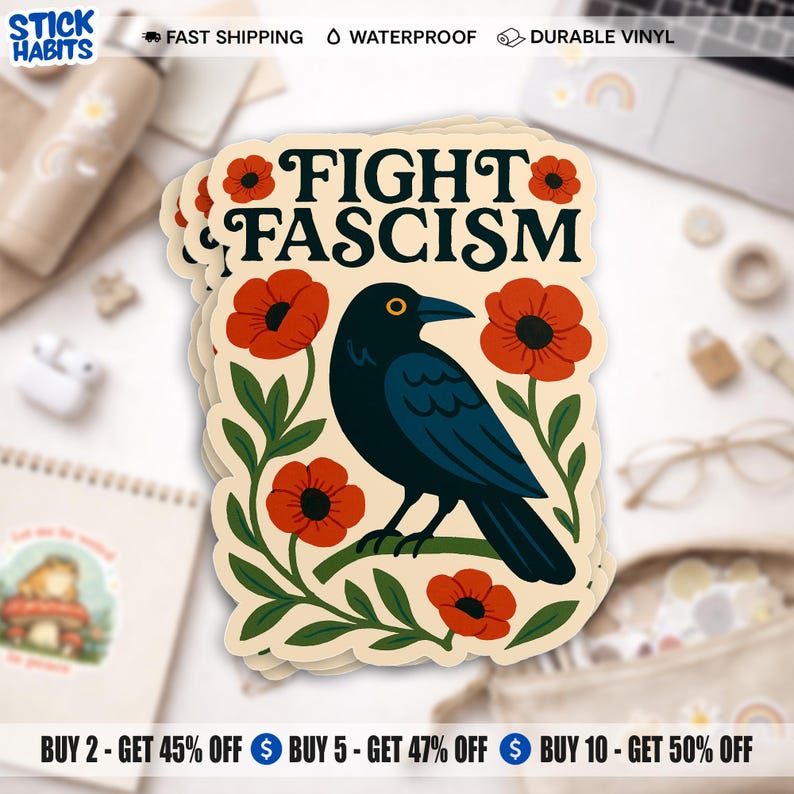 May include: A die-cut sticker with a cream background featuring a black crow perched on a green branch, surrounded by red poppy flowers. The text FIGHT FASCISM is printed in bold black capital letters at the top of the sticker design.