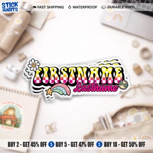 Puede incluir: Una pegatina colorida con el texto "FIRSTNAME Lastname" en una fuente retro. La pegatina presenta una margarita, un arcoíris y un símbolo de la paz. Se encuentra sobre una superficie blanca con otros artículos de papelería.