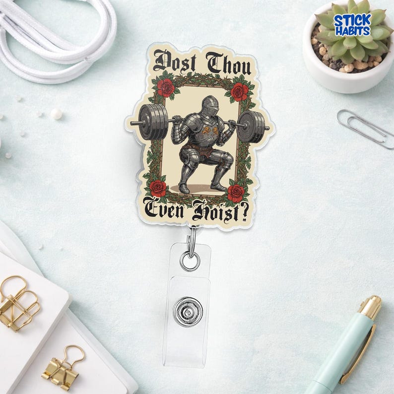Op de afbeelding: Een badge reel met een ridder die gewichten heft, omlijst door rozen en groen. De tekst luidt "Dost Thou Even Hoist?" in een middeleeuws lettertype. De reel heeft een doorzichtige plastic band en een metalen clip.