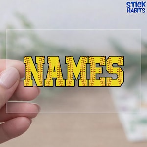 May include: A clear sticker with the word "NAMES" in yellow, baseball-style lettering. The letters are outlined in black and feature red stitching details, mimicking a baseball. The sticker has the text "STICK HABITS" in the upper right corner.